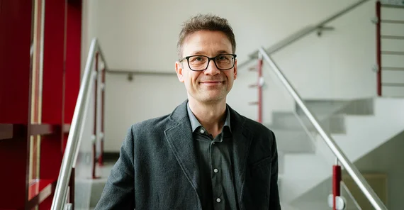 Prof. Dr. Kevin Dadaczynski lächelnd im Porträt