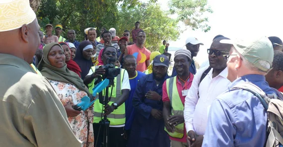 Dr. Michael Burkart (on the right in a blue shirt) presenting gifts to members of the CBO. Many of them wear yellow vests with the logo of the garden, an ancient kapok tree. The photo is from Dr. Michael Burkart.