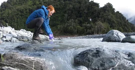 Aaron Bufe beprobt Flusswasser.