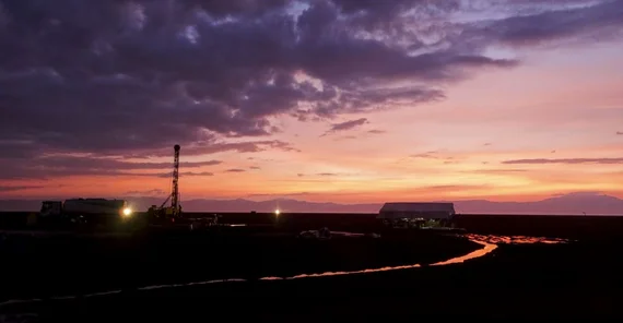 Bild mit Sonnenuntergang und Bohrturm im Hintergrund