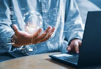 Eine Hand mit visualisierten Daten vor einem Laptop