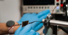 Two hands holding a component for a solar cell