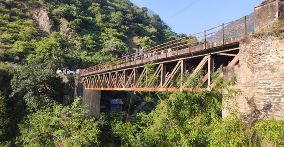 Von einer alten Brücke über den Baghirati aus führt die Gruppe eine Messung der Fließgeschwindigkeit durch.