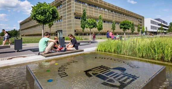 Studierende vor dem „Goldenen Käfig“ (Haus 28), Sitz des Instituts für Physik und Astronomie, auf dem Universitätscampus Potsdam-Golm. Foto: Thomas Roese.