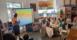 Blick in den Gastraum eines Cafés, wo ein Forscher einen Vortrag hält