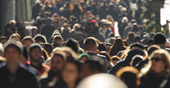 Blick in eine Menschenmenge auf einem Gehweg. Kein Gesicht ist klar auszumachen.