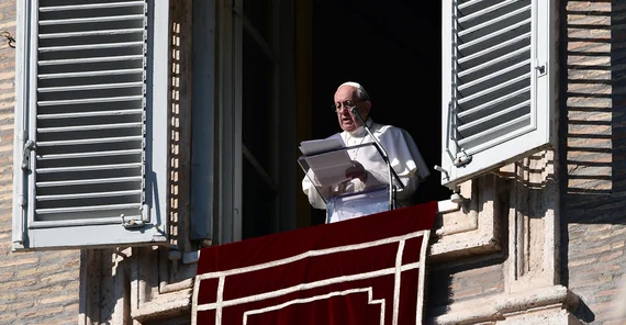 Papst Franziskus steht am Fenster und liest von einem Blatt ab
