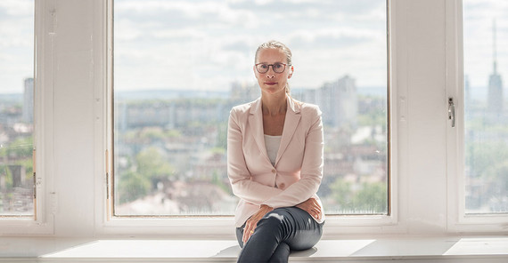 Prof. Dr. Frauke Brosius-Gersdorf im Porträt auf einer Fensterbank sitzend.
