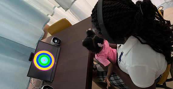 Sprachstudie in Gahana. Mutter und Baby sitzen vor einem Bildschirm