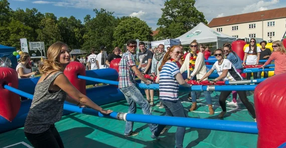 Studierende agieren als Tiscgfußballfiguren beim Spiel