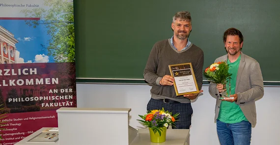 Preisträger posiert mit einem zweiten Mann für ein Foto