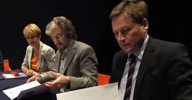 2 Männer und 1 Frau an einem Tisch beim anschauen von Unterlagen