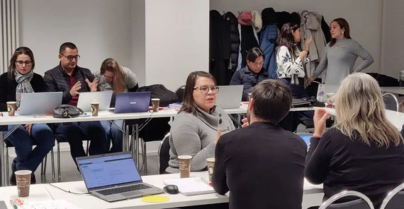 Menschen in einem Konferenzraum in verschiedenen Gruppen, die sich unterhalten.
