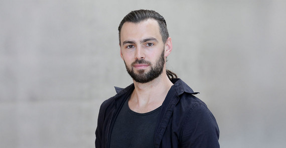 Steffen Hagemann in a portrait in front of a grey concrete wall on the Griebnitzsee campus.