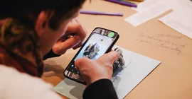 Eine Person schaut auf ein Smartphone.