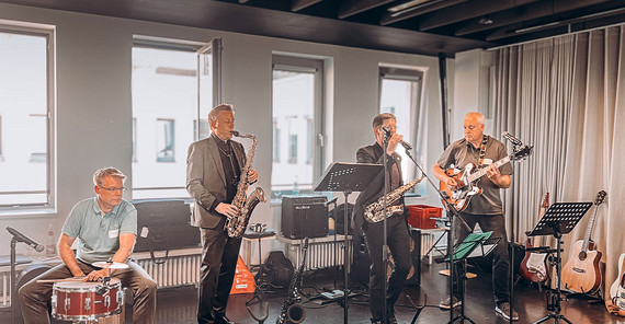 Vier Wissenschaftsmanager als Band auf der Bühne für ein Geburtstagstagsständchen