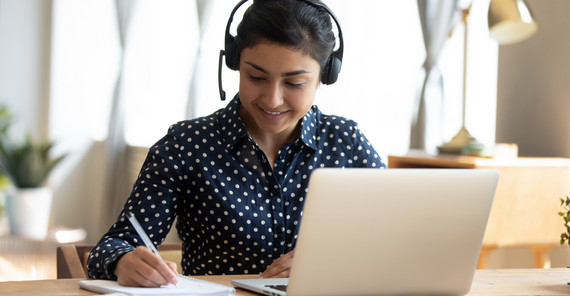 Studentin im Homeoffice sitzt am Laptop un arbeitet. Das Foto ist von AdobeStock/fizkes.