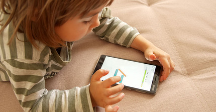 Kleinkind spielt mit Smartphone.