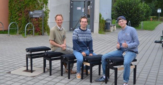 Detlef Pauligk (l.) testet mit den Studierenden die gemeinsam reparierten Klavierhocker.