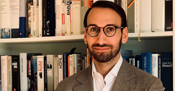 Portrait von Dr. Bastian Matteo Scianna vor einem Bücherregal.