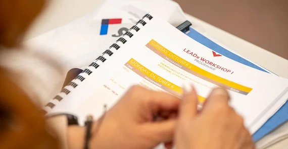 Close-Up auf Unterlagen und Hände einer teilnehmenden Person.