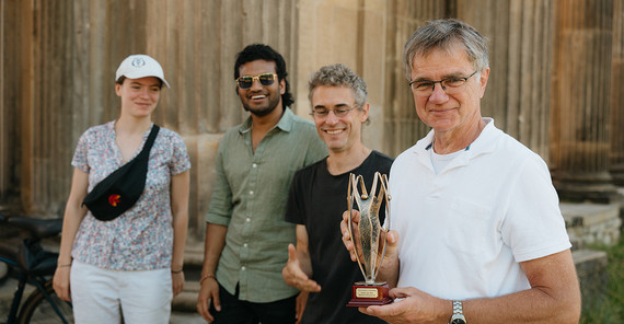 Vier Personen mit einem Preis