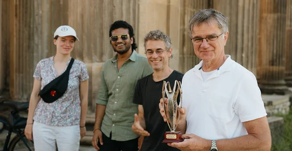 Vier Personen mit einem Preis