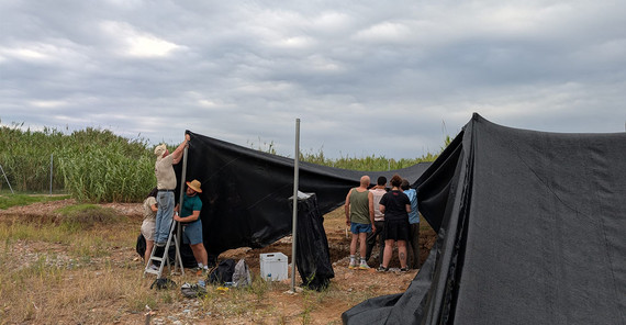 Schwarze Sonnenschutzzelte werden von mehreren Studierenden abgebaut.