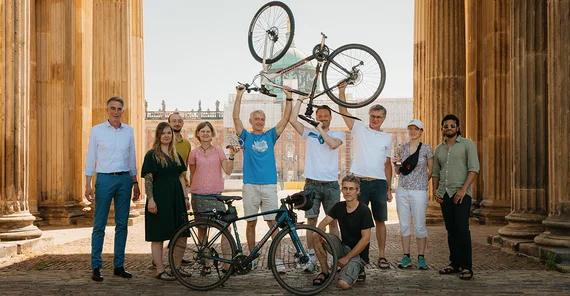 Gruppe von Menschen posiert mit Pokalen und Rädern für ein Foto
