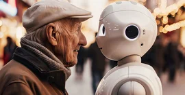 Älterer Mann steht einem Roboter Kopf an Kopf gegenüber.