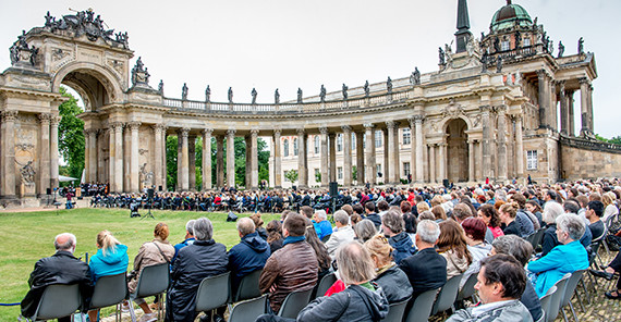 Absolventenverabschiedung 2016 (Foto: Karla Fritze) Gäste sitzen vor den Kolonnaden und verfolgen das Programm