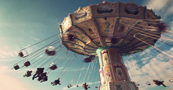 Bild: Adobe Stock/ Tom Bayer. Auf dem Bild ist ein fahrendes Kettenkarussel abgebildet.