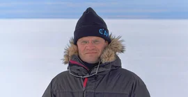 Prof. Dr. Markus Rex im Porträt vor eisigem Horizont auf Expedition in der Antarktis.