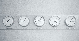 Das Bild zeigt fünf Wanduhren mit unterschiedlichen Uhrzeiten.