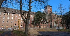 Der alte Landtag auf dem Brauhausberg. Bild im Winter mit kahlen Bäumen im Vordergrund, sowie Sandbergen von Baumaßnahmen.