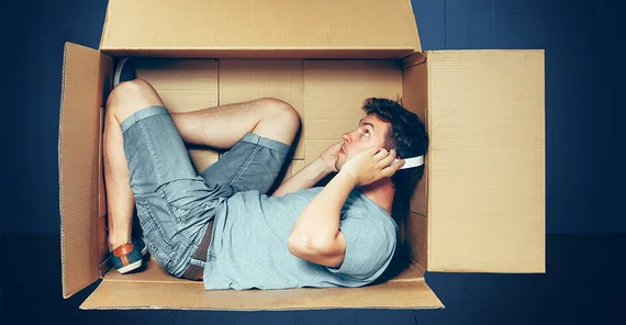 Foto: Adobe Stock/ master1305. Ein Mann sitzt in einem Karton.