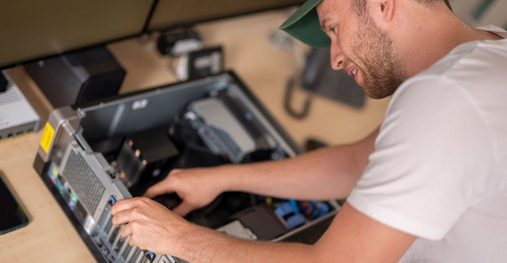 Person working on an open PC tower.